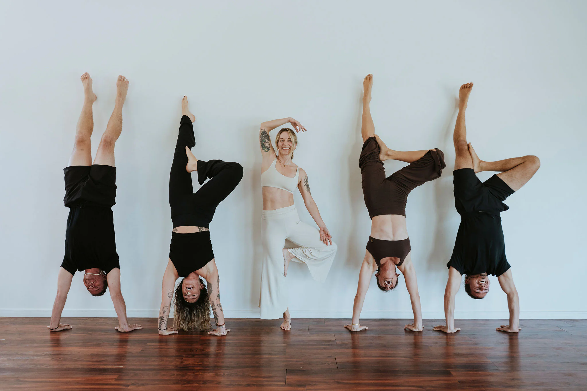 Students practising handstands against the studio wall
